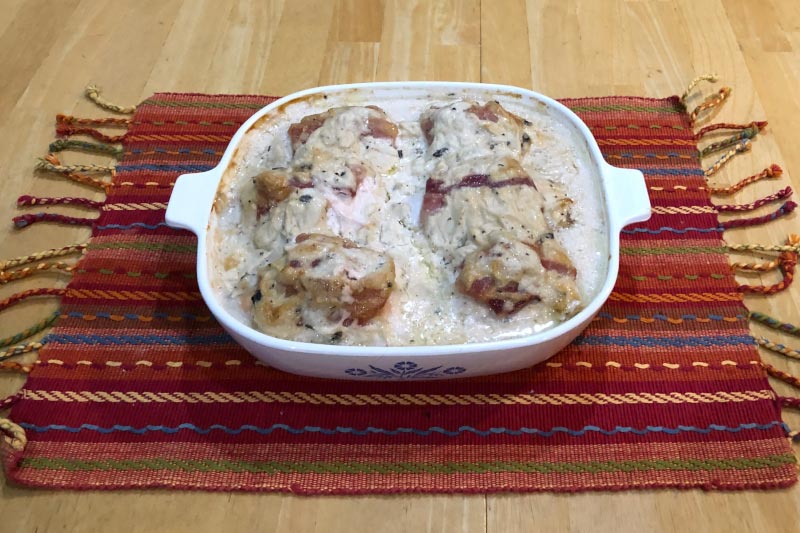 Photo of baked Party Chicken Breasts on cloth placemat on wooden table